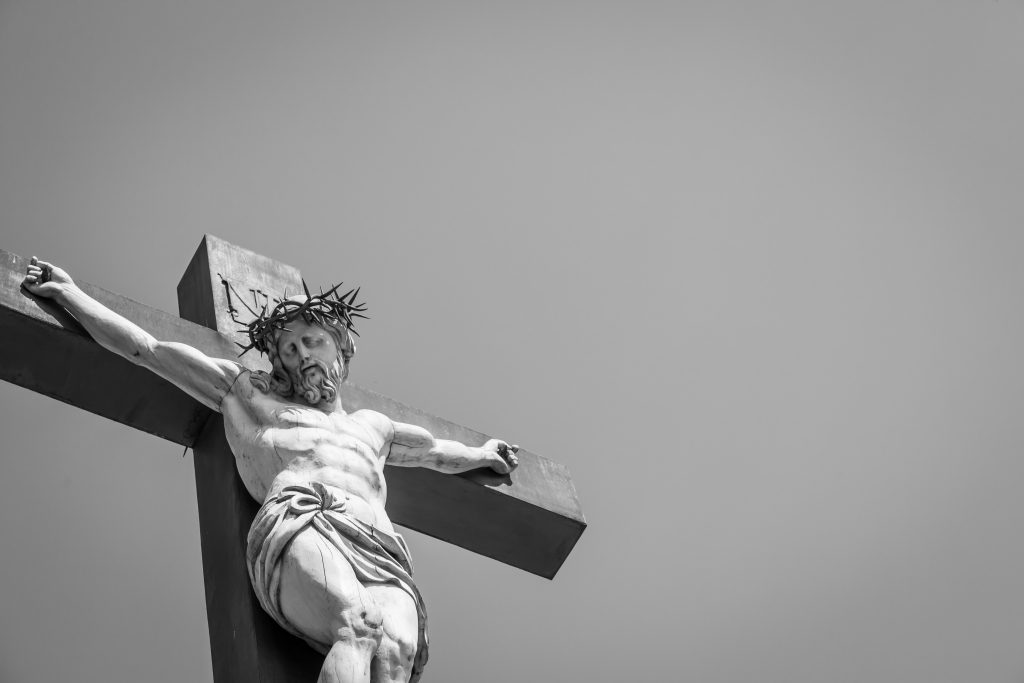 Crucifix made of marble with blue sky in background. France Provence Region.